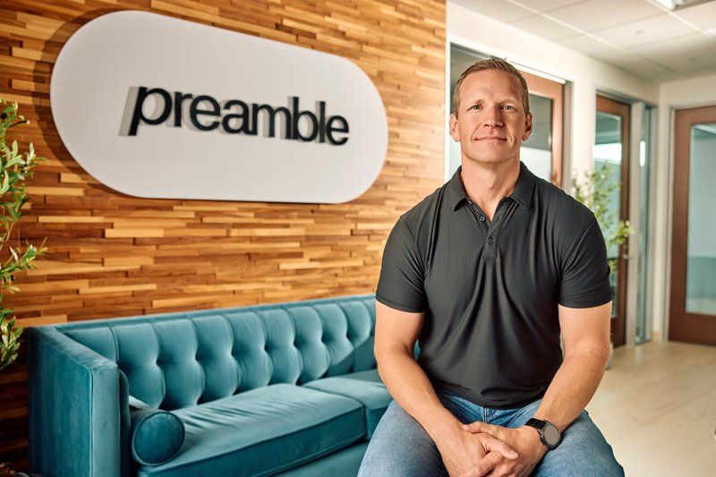 Jesse, founder of Preamble, seated on the clinic's teal couch